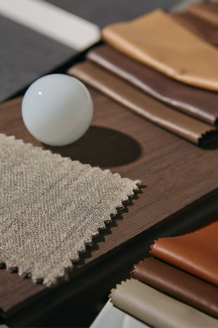 close shot of material samples like wood, leather, fabric and a Murano glass in the middle