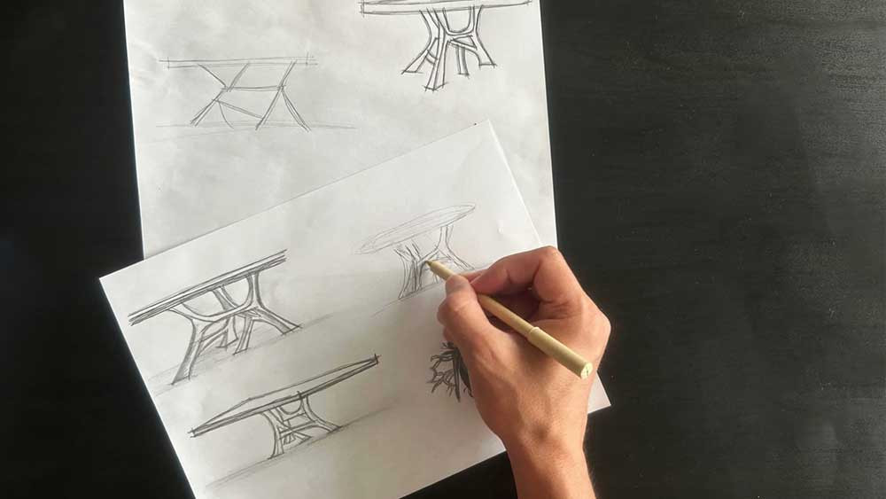 design sketch of the vena dining table with a hand with a pen